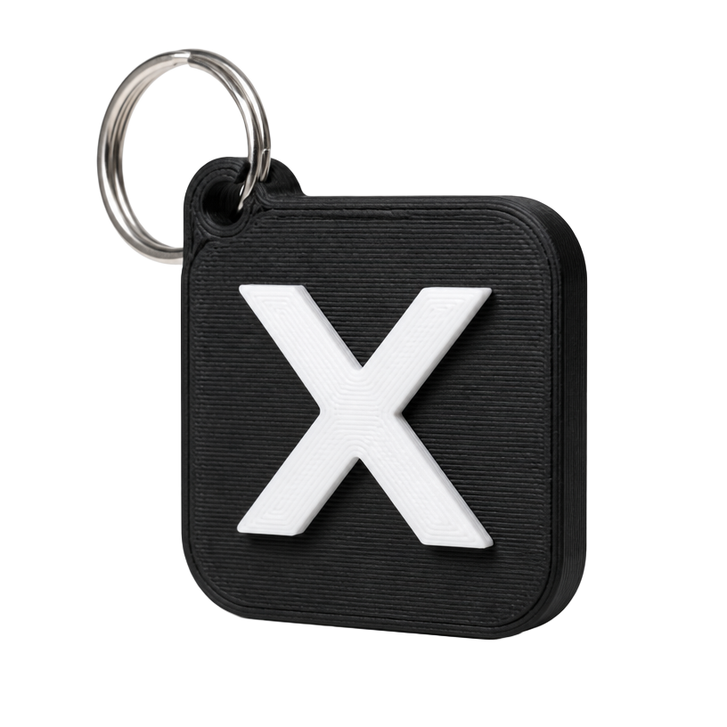 3D printed black NFC keychain tag with a white X